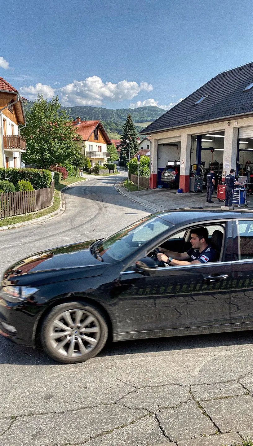 Interiér servisu so zamestnancami pracujúcimi na rôznych typoch motorov, zameraný na kvalitu a presnosť.